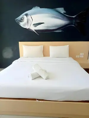 a bed with a fish painting on the wall at GO INN Krabi Ao Nang Beach - โกอินน์ อ่าวนาง in Ban Khlong Haeng