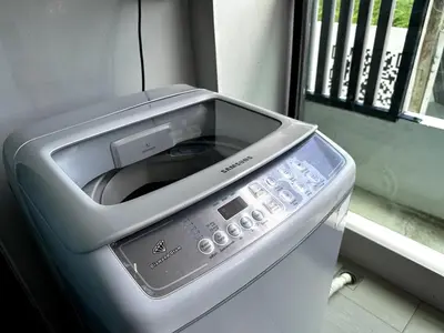 a washing machine with its door open next to a window at Royal Lee Airport Phuket in Ban Bo Han