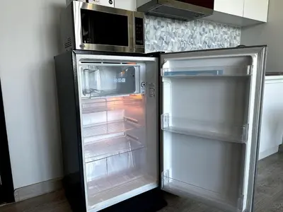 an empty refrigerator with its door open in a kitchen at Royal Lee Airport Phuket in Ban Bo Han