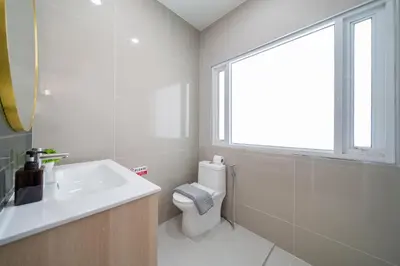 a bathroom with a toilet and a sink and a window at 7BR Patong pool villa in Patong Beach