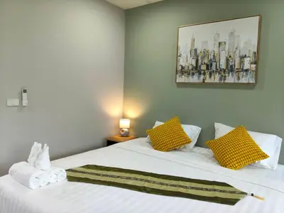 a bedroom with two beds with yellow and white pillows at Le Wadee Residence in Bang Tao Beach