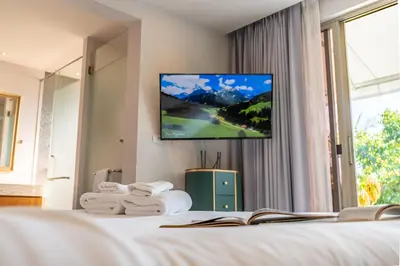a hotel room with a tv on a bed at Botanica 4 BR Villa Layan Beach in Ban Phru Champa
