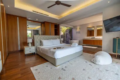 a bedroom with a large white bed and a television at Botanica 4 BR Villa Layan Beach in Ban Phru Champa
