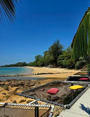 a beach with two umbrellas and the ocean at Krabi Sea view, Lilly Beach Room Balibar in Krabi town