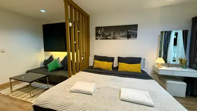 a bedroom with a large bed with yellow and green pillows at Apartment with a view near the park in Ban Rangeng