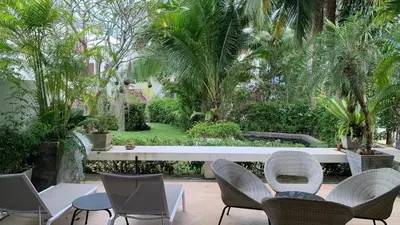 a patio with chairs and a table and trees at Tranquil 2-Bedroom Getaway - Celeena #870 in Rawai Beach