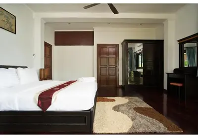 a bedroom with a large white bed and a rug at Lumaya Rawai in Rawai Beach
