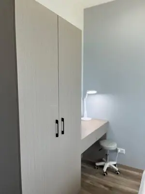 a white cabinet with a desk and a chair at UPMOON Hotel Chalong Phuket in Ban Suan