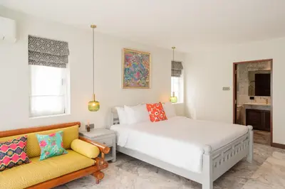 a white bedroom with a bed and a couch at Villa Melita 5 bedrooms, hillside location with pool and seaview in Kata Beach