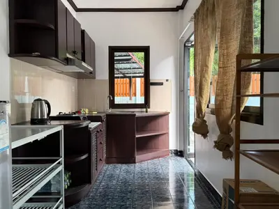 a kitchen with black cabinets and a window at Jungle style apartments in Kamala in Kamala Beach
