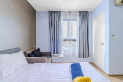 a bedroom with a bed and a couch and a window at C232 Prime spot Pool Gym Near Beach&Boat Ave in Bang Tao Beach