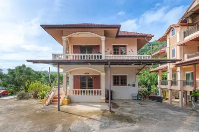 a house with a balcony on top of it at Serenity Holiday Villa 2, Karon Beach in Karon Beach