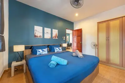 a blue bedroom with a large bed with blue sheets at Serenity Holiday Villa 2, Karon Beach in Karon Beach
