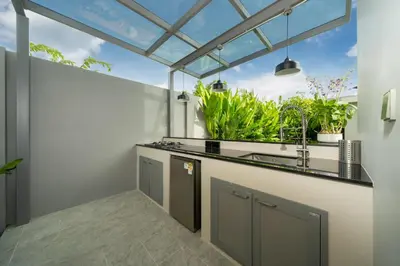 a kitchen with a sink and a window with plants at Riverhouse Phuket - Private Pool Villas by Escape Villas in Laguna Phuket
