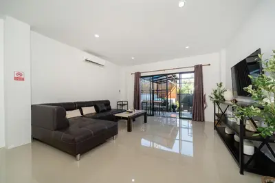 a living room with a couch and a table at Rawai Pool House with 3 Bedrooms in Ban Saiyuan (1)