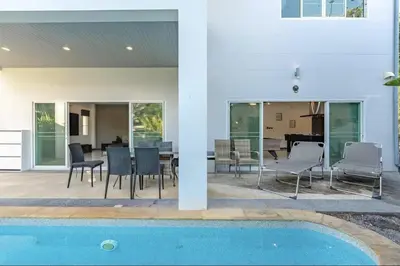 a house with a pool and chairs and a table at V161 Quiet 4BR with Pool Table, 3 Min to Rawai Beach in Rawai Beach