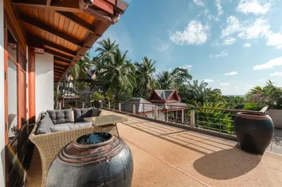a balcony of a house with two large vases at Surin Ayara Villas by Stayisle in Surin Beach