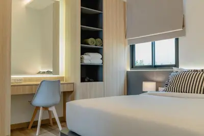 a bedroom with a white bed and a blue chair at New 3BR Pool Villa w Jacuzzi Ao Nang Krabi in Ban Khlong Haeng