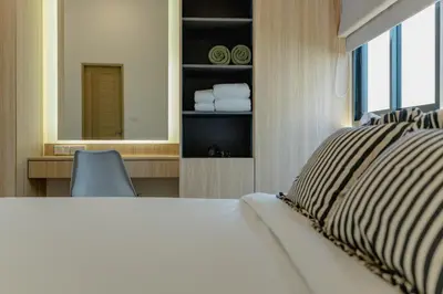 a bedroom with a bed and a desk and a mirror at New 3BR Pool Villa w Jacuzzi Ao Nang Krabi in Ban Khlong Haeng