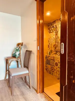 a dining room with a chair and a wall mural at Village 40 Phuket Old Town in Phuket Town