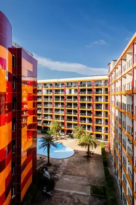 an apartment building with a courtyard and palm trees at North Gate Apartments in Ban Mai Salae