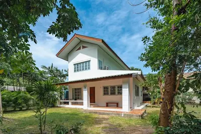 a white house with a red roof at Naiharn Beach Holiday Villa, Rawai Phuket in Rawai Beach