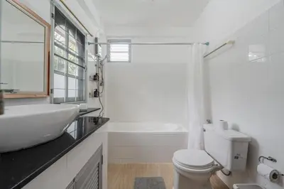 a white bathroom with a sink and a toilet at Naiharn Beach Holiday Villa, Rawai Phuket in Rawai Beach