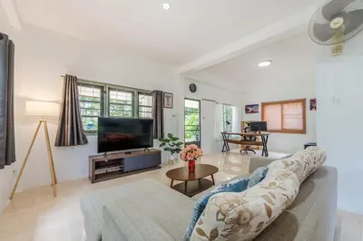 a living room with a couch and a tv at Naiharn Beach Holiday Villa, Rawai Phuket in Rawai Beach