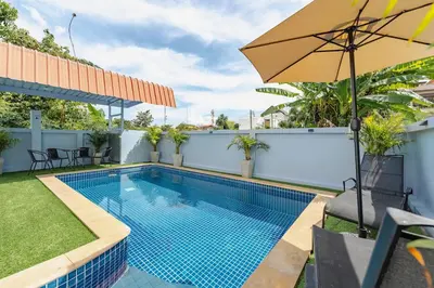 a swimming pool with an umbrella next to a fence at Family Sea View Holiday Pool Villa, Saiyuan Phuket in Ban Saiyuan (1)