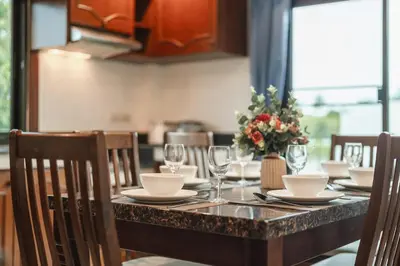a table with plates and glasses and a vase of flowers at Family Sea View Holiday Pool Villa, Saiyuan Phuket in Ban Saiyuan (1)