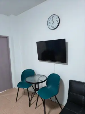 a room with two chairs and a table and a clock at Kata beach weivs in Kata Beach