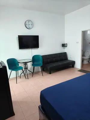 a living room with a couch and a table and a clock at Kata beach weivs in Kata Beach