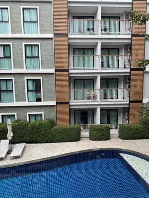 a building with a swimming pool in front of a building at Title 5 in Rawai Beach