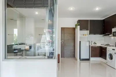 a kitchen with a sink and a refrigerator in a room at Chic Condo by Bcare - Purple Rose in Karon Beach
