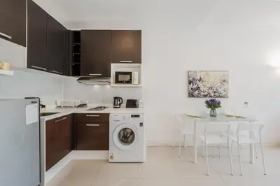 a kitchen with a washing machine and a table at Chic Condo by Bcare - Purple Rose in Karon Beach