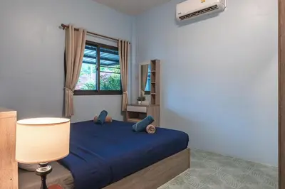 a bedroom with a blue bed and a window at Areca Holiday Home 3, Karon Beach in Karon Beach