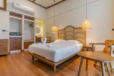 a bedroom with a large bed and a table at Private Designer Villa with Pool Prime Rawai 3 beds in Ban Saiyuan (1)