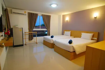 a hotel room with two beds and a window at Leelawadee Naka in Phuket Town