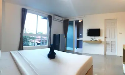 a bedroom with a bed with a cat sitting on it at Leelawadee Naka in Phuket Town