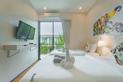 a large bedroom with two beds and a television at D401 Title Rawai Beach Front 2 Bedroom Apartment in Rawai Beach