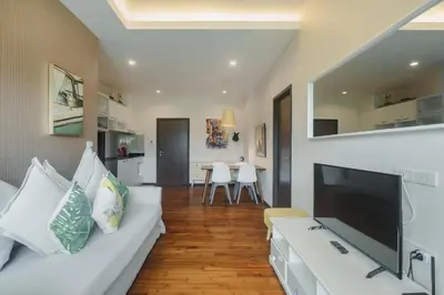 a living room with a white couch and a flat screen tv at D401 Title Rawai Beach Front 2 Bedroom Apartment in Rawai Beach