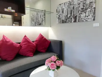 a living room with a couch and pink pillows at A Fully Furnished Condo in the Phuket Center in Ban Ket Ho