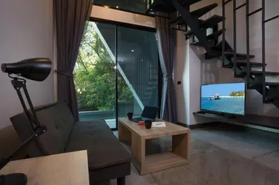 a living room with a couch and a television at Duplex Loft near Nai Harn Beach with Pools & Gym - Utopia Loft B125 in Rawai Beach