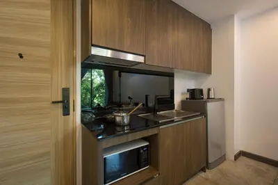 a kitchen with a stove and a refrigerator at Duplex Loft near Nai Harn Beach with Pools & Gym - Utopia Loft B125 in Rawai Beach