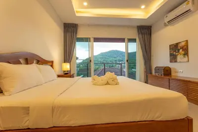 a bedroom with a large bed with a large window at C126 Walk to Beach Global & Local Eats Pool & Gym in Rawai Beach