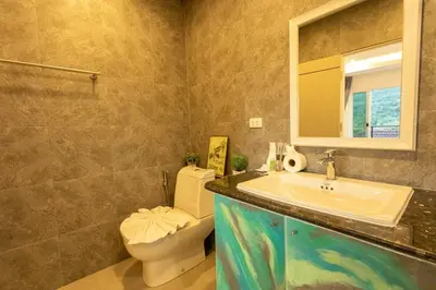 a bathroom with a sink and a toilet and a mirror at C126 Walk to Beach Global & Local Eats Pool & Gym in Rawai Beach