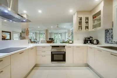 a white kitchen with white cabinets and appliances at Koson Elegant 3 Bedroom Villa in Rawai Beach