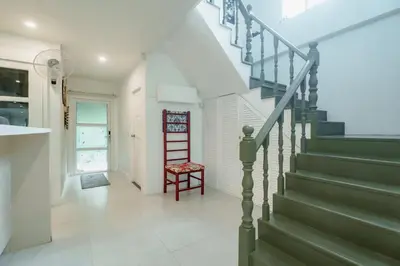 a staircase in a house with a red chair at Koson Elegant 3 Bedroom Villa in Rawai Beach