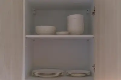 a cupboard with plates and bowls in it at The Ozone Lounge Lovers Golf View Bangtao in Laguna Phuket