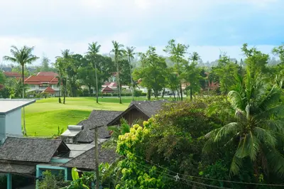 a view of a golf course with trees and houses at The Ozone Catisse Golf View Bangtao in Laguna Phuket